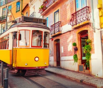 A vintage yellow tram is shown going down a hill in a traditional Lisbon street