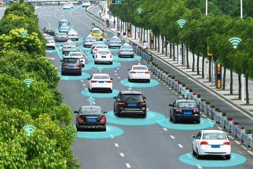 Several autonomous vehicles on a motorway. The cars are shown with circles around them to signify they are connected